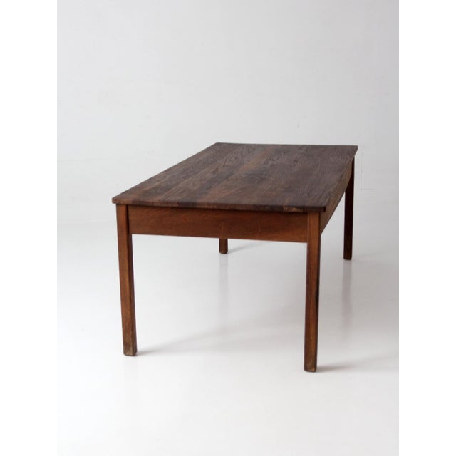 Early 20th-century antique oak schoolhouse table with a beautifully worn solid oak top and clean, utilitarian lines. Rich...