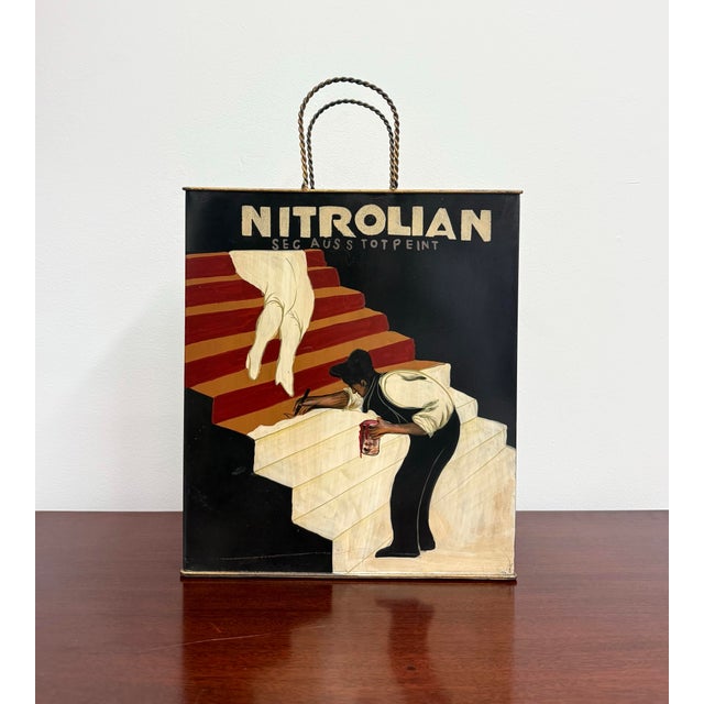 A hand-painted metal magazine holder inspired by Leonetto Cappiello’s iconic Nitrolian advertising poster. Featuring the...