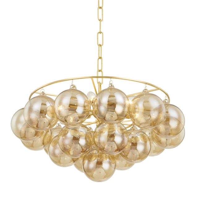 Gorgeous champagne glass globes are clustered around an elegant Aged Brass frame to create a statement piece that is...