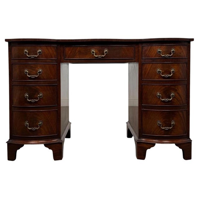 A handsome and beautifully crafted early 20th-century English kneehole desk, finely constructed in mahogany and...