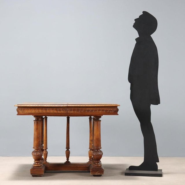 Walnut table. Rectangular top with carved molding and banding, supported by four turned and carved legs, plus three...