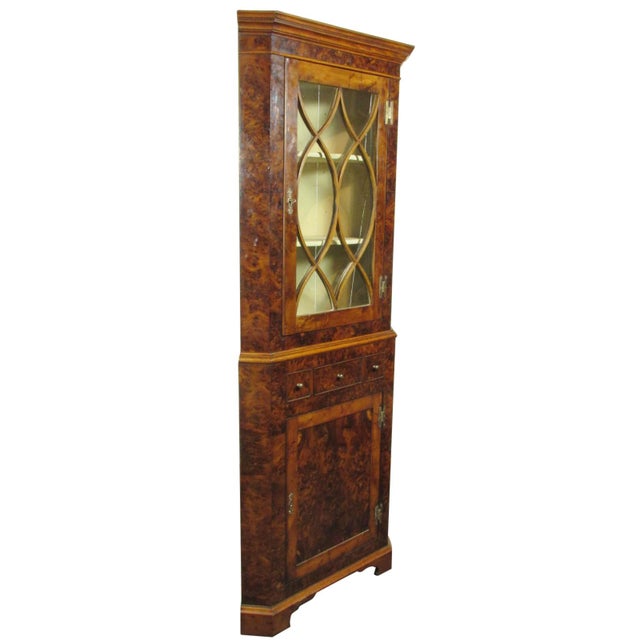 A 19th-C. English burl walnut corner cabinet with a glazed upper door and a solid panel lower door. Doors function with...