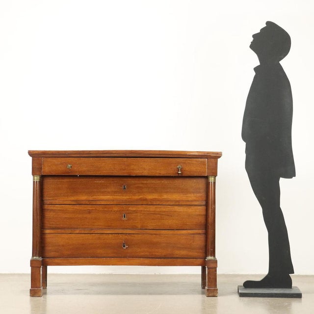 Empire chest of drawers in walnut, front with four drawers, the first of which juts out. Turned columns with base and...