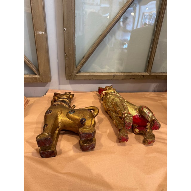 This is a stunning pair of hand carved wooden fu dog sculptures. They have an open mouth and raised tail. They also have...