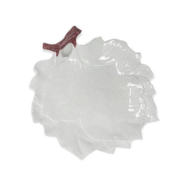 A leaf-shaped tray finished with a natural brown branch handle, hand-painted in Italy. As hand-painted work, expect slight...