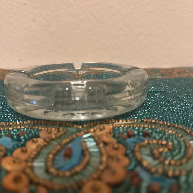 This classic Mid-Century Modern advertising ashtray is a beautifully preserved piece of 1960s hospitality memorabilia....