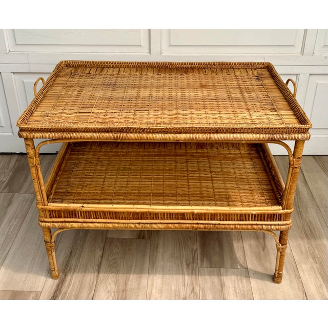 This beautifully crafted vintage bamboo, rattan, and wicker table features an elegant two-tier design with exceptional...