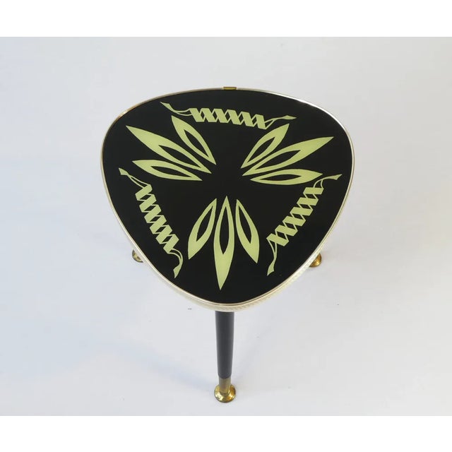 Original unique mid century table with a glass and a nice abstract pattern inside surrounded by a brass rim. The unique...