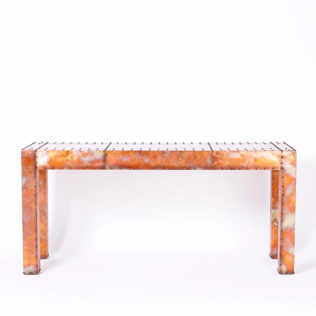 Midcentury Parsons style console table methodically clad in burnished copper panels highlighted with copper tacks.