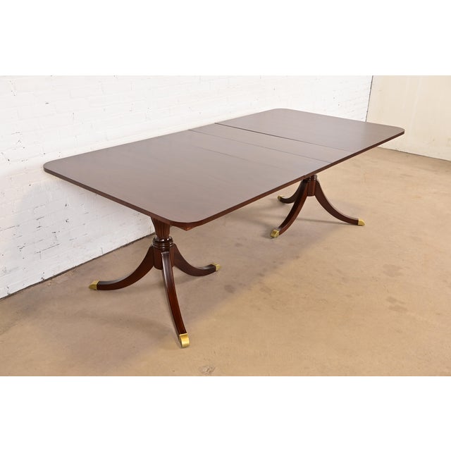 An exceptional Georgian or Regency style double pedestal extension dining table In the manner of Baker Furniture USA,...