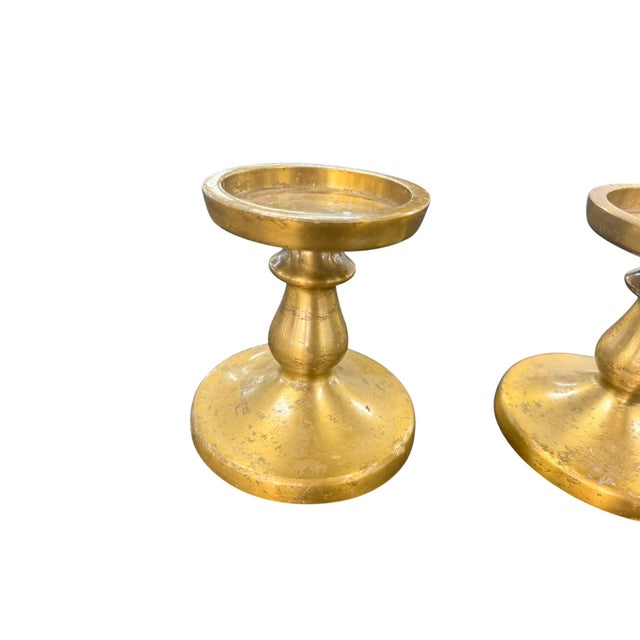 Each candlestick rises on a turned baluster stem from a weighted oval base to a wide, shallow drip pan designed to catch...