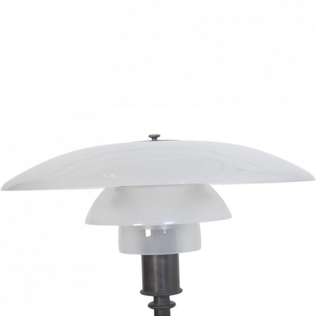 Poul henningsen patented ph4-3 table lamp with a frame of browned brass and shades of frosted opal glass. The lamp is from...