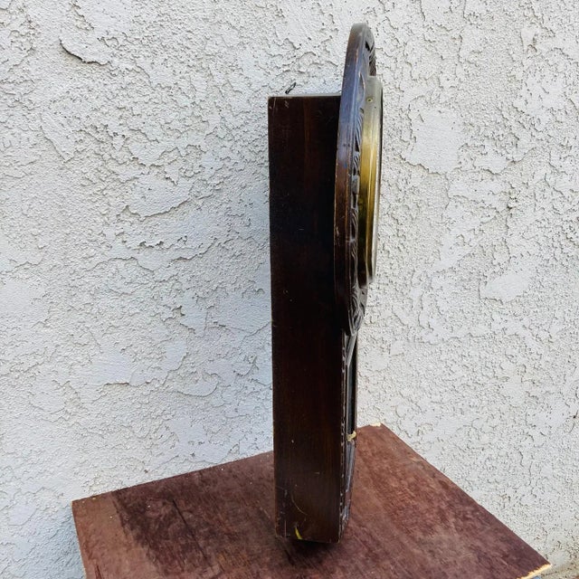 This is a vintage Regulator clock dating back to the mid 20th Century. It has a 'rolling pin" case made from mixed wood...