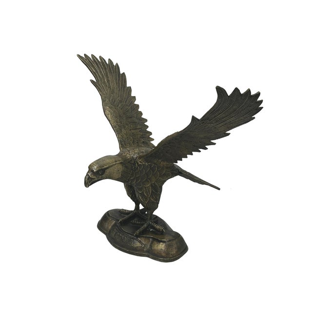 This striking bronze eagle sculpture captures the majestic power and grace of the raptor in a moment of poised intensity....