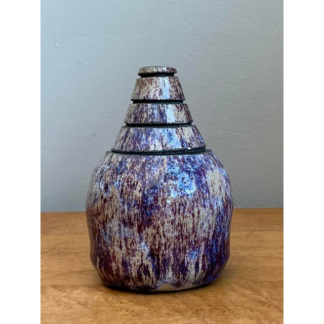 This striking artisanal lidded jar is a testament to the expressive nature of late 20th-century studio pottery. The vessel...