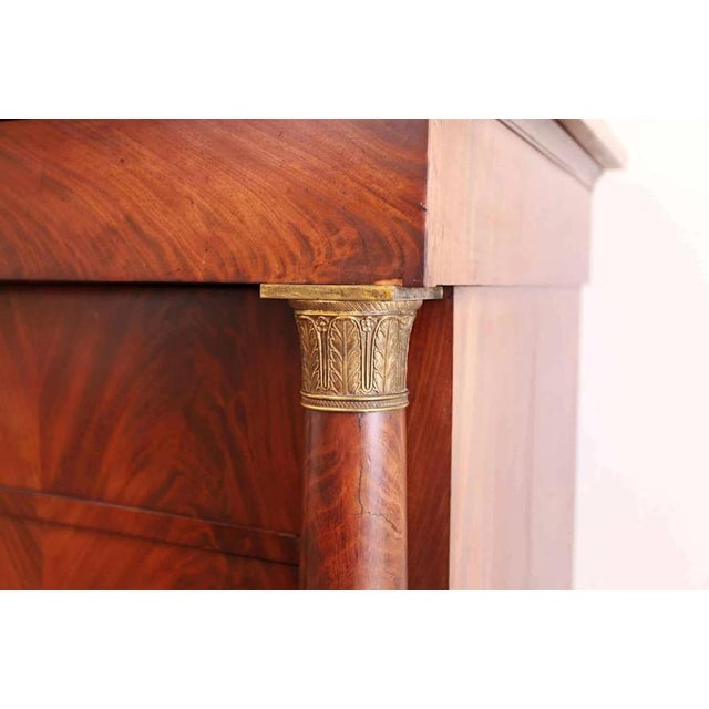Antique classicist chest of drawers made of solid oak, refined with mahogany veneer, which is mirror-folded into patterns....