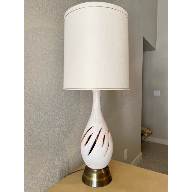 Elegant, airy, and uplifting bright white mid century modern table lamp with dynamic flame incisions for added depth and...