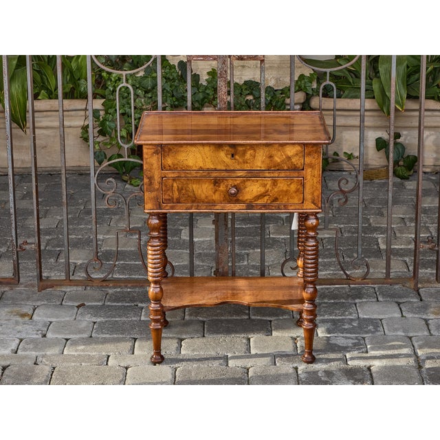 A midcentury English walnut side table, circa 1940–1950, with turned legs and two drawers. This finely crafted piece...