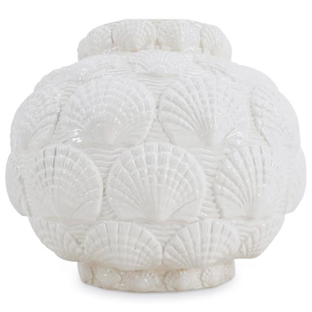 A vintage Royal Haeger white ceramic table lamp with glossy glazed shell decoration. A brass harp and finial are included...