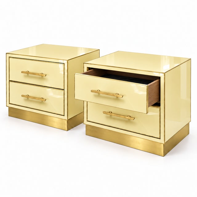 A pair of contemporary italian bedside tables in a warm butter-yellow murano glass finish, with polished brass edging and...