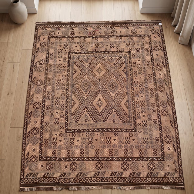 A large handwoven Afghan kilim in a soft camel and chocolate palette, built on a concentric plan that is unusual among...