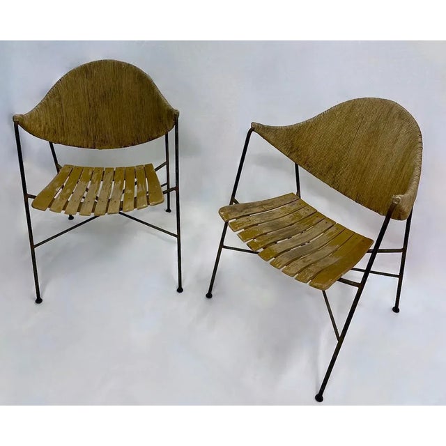 Pair of vintage Mid-Century Modern iron and hemp Arthur Umanoff chairs with slatted wood seat. Hemp backrest. No maker's...