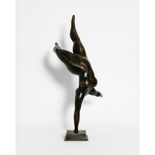 A contemporary figurative bronze of a woman caught mid-leap, body stretched into a single soaring diagonal — legs flung...