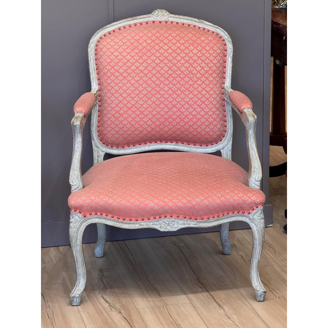 A pair of late 18th C. French carved and painted fauteuils with shaped backs and seats, scrolling arms, and cabriole legs....