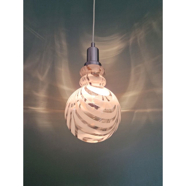 Slightly smoked Murano glass pendant light with white spirals, chrome-plated metal frame, 1970s. The pendant has been...