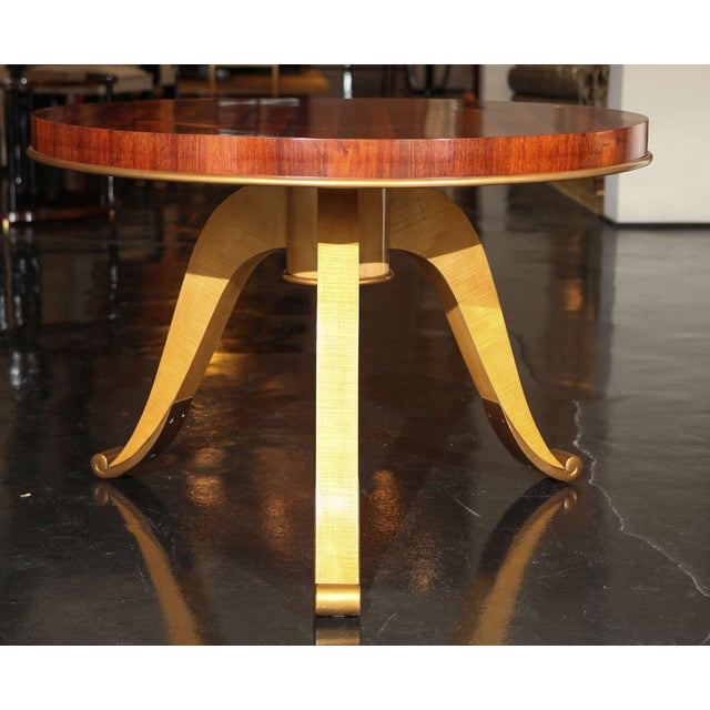 Coffee table with linear grained rosewood veneer top. Raised on three curved legs of fruitwood. Gold Leaf detailing on...