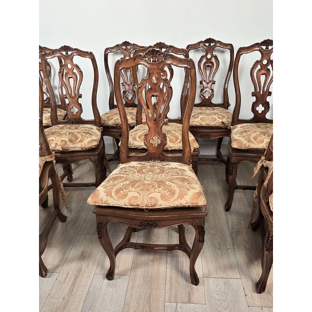 A set of eight Italian fruitwood provincial dining chairs, circa 1920. The side chairs measure 41.75" h 20" seat (with...