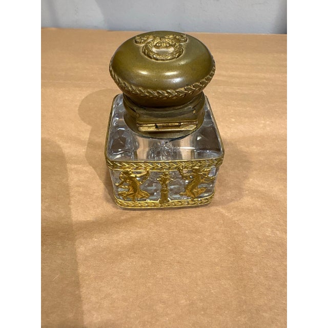 This is a stunning antique inkwell. It is French circa the 19th century. The body is glass, with a brass top. This inkwell...