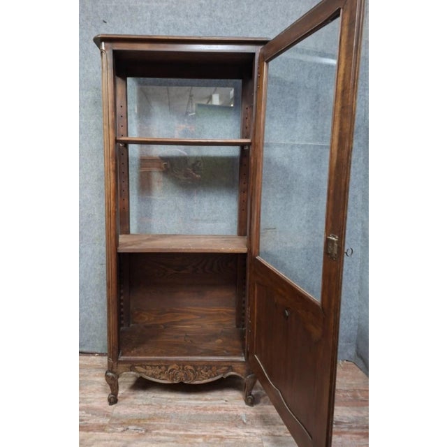 A Louis XV style walnut display cabinet, French work from the mid-20th century. Curved design with a glazed door in the...