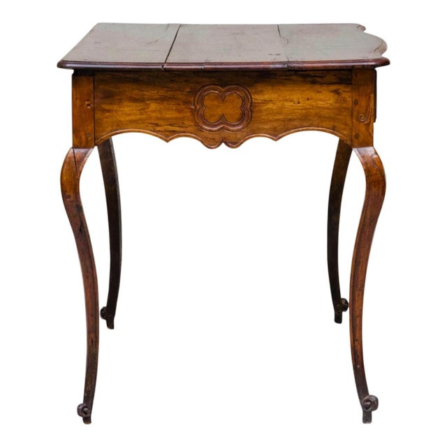 An elegant Louis XV carved table resting on long and graceful cabriole legs, the serpentine front fitted with a single...