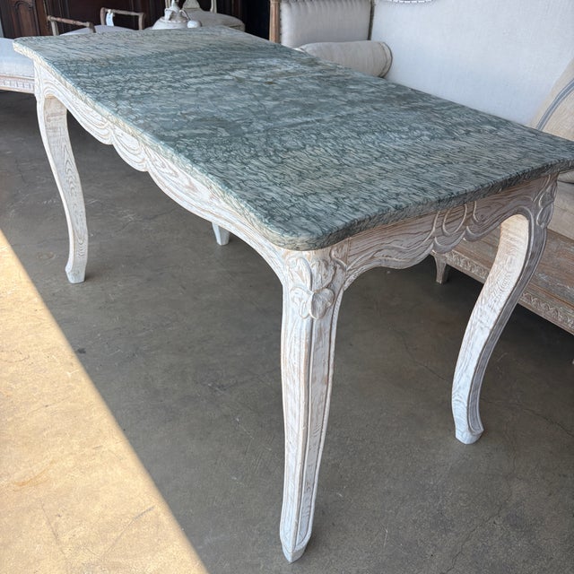 Wonderful Louis XV style console table with carved frame paired with a stunning marble top. The console table originated...