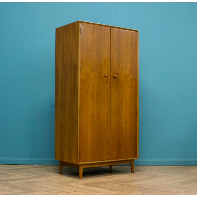 A freestanding double door teak wardrobe from Gimson & Slater. Made during the 1960s It's fitted with a clothes rail and...