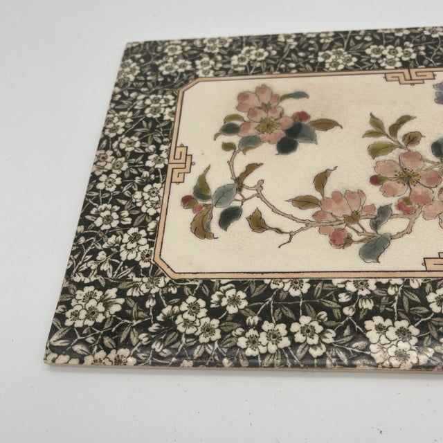Aesthetic Period tile trivet of glazed ceramic with a brown floral border, central white ground with asiatic style floral...