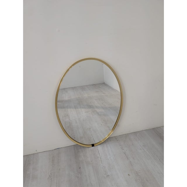 Large oval mirror in a golden brass frame – minimalist, vintage Elegant oval mirror in a slim golden brass frame. Its...