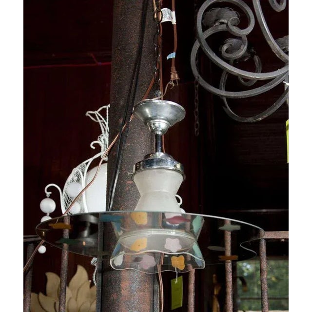 Mirrored palette with painter's paint splotches hanging light from Paris. Accommodates one bulb.