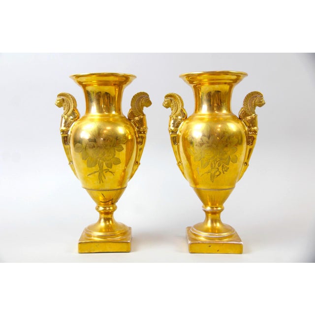 An elegant pair of French Old Paris porcelain decorative vases, inspired by the refined Empire style and richly ornamented...