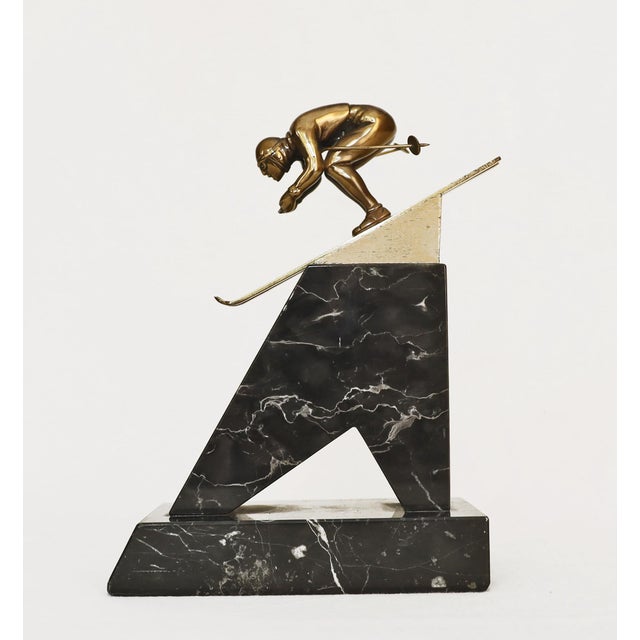 Bronze ski jumper Bronze figure of an athlete. Mounted on a two-part marble base. Dated 1972.
