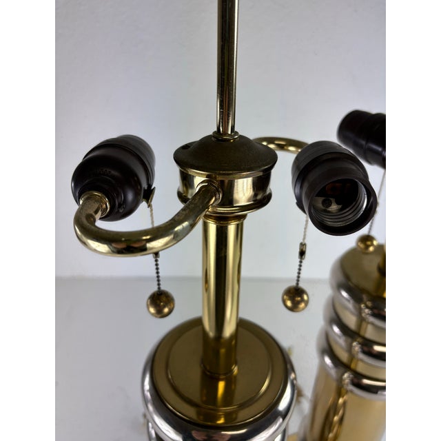 This is a pair of glamorous mid-century vintage modern brass and chrome table lamps. These table lamps have a brass...