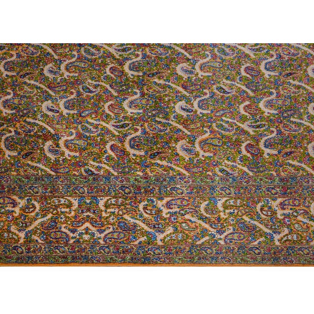 An unbelievable mid-20th century Persian Kirman rug with an intensely woven paisley and floral pattern woven in myriad...