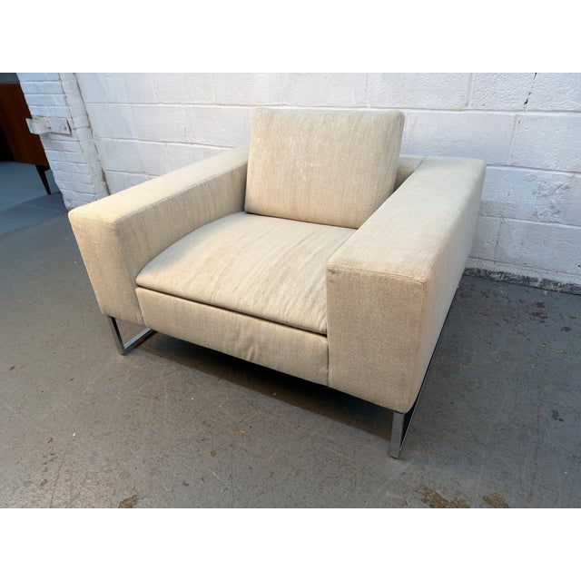 A sophisticated Mid-Century Modern lounge chair featuring a clean, architectural silhouette and generously proportioned...
