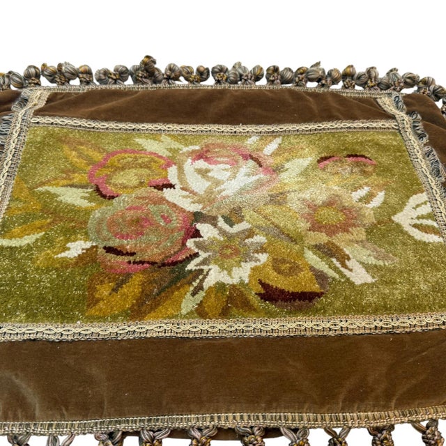 A distinctive vintage French cushion cover featuring a decorative Savonnerie-style floral panel, framed by layered trims...