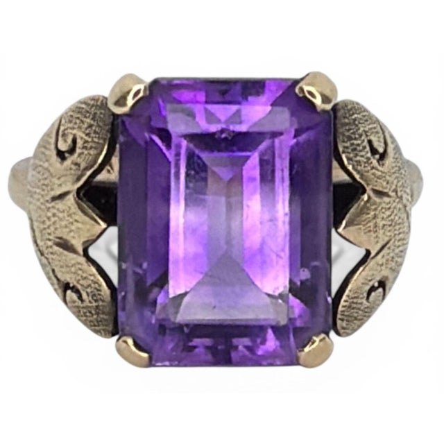 Sculptural Art Deco 14K Gold Amethyst Ring. Stone is in an emerald cut and measures approximately 12mm x 11mm, securely...