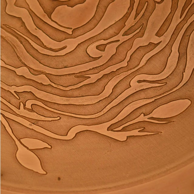 Large hand spun copper dish with floral motive etched deep into the surface. The bowl was designed as a wall decoration as...