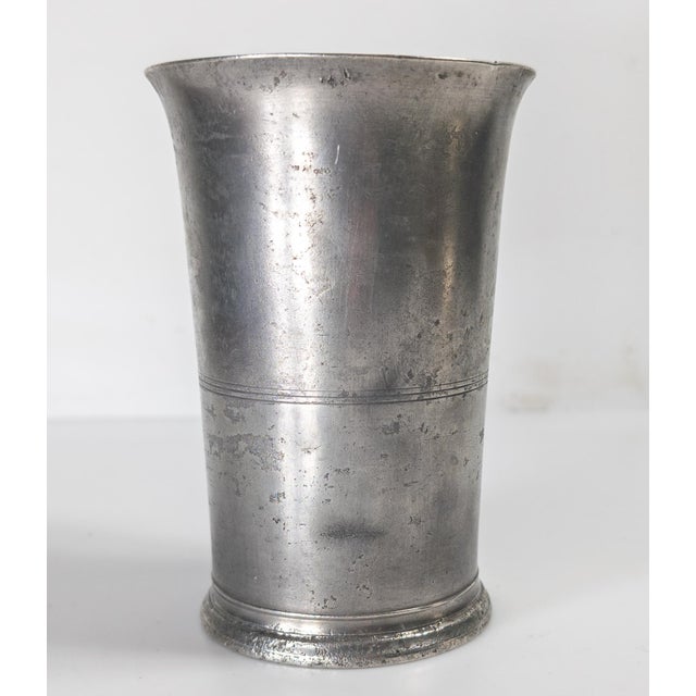 We are offering this early American pewter beaker cup. This cup has nice simple and elegant form with three central...