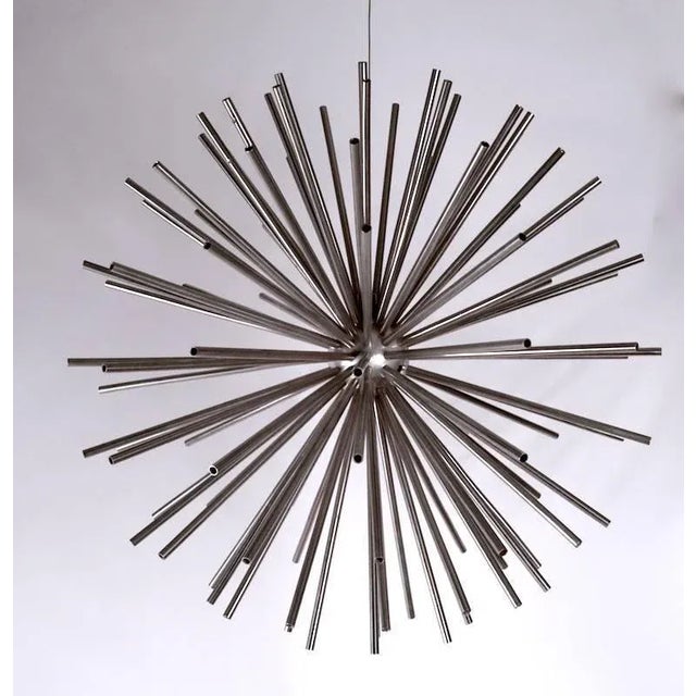 Two chromium plate steel Sputnik ball form sculptures. One hangs, the other rests on the surface, one is missing a tube,...