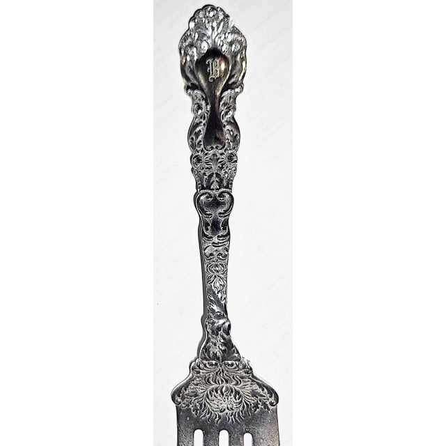 Still stunning after 130 years, a Gorham sterling silver cold cut serving fork in their chrysanthemum pattern, 2.58 troy...